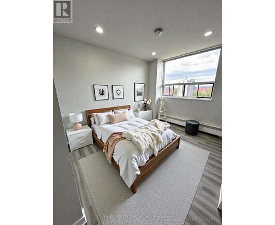 A bedroom with a large bed and a window overlooking a cityscape.