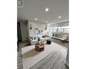 A living room with a white couch, a wooden coffee table, and a rug.