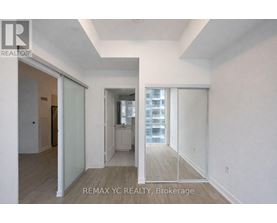 A brokerage sign is on the wall of a large, empty room.