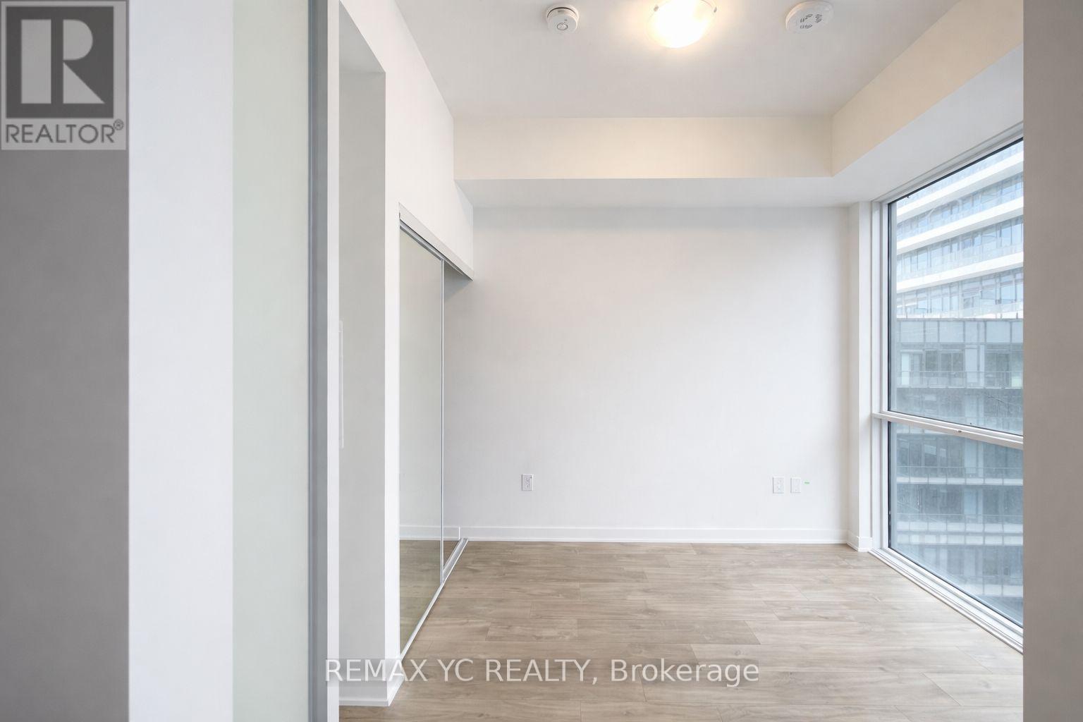 A room with a large window and a wooden floor.