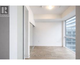 A room with a large window and a wooden floor.