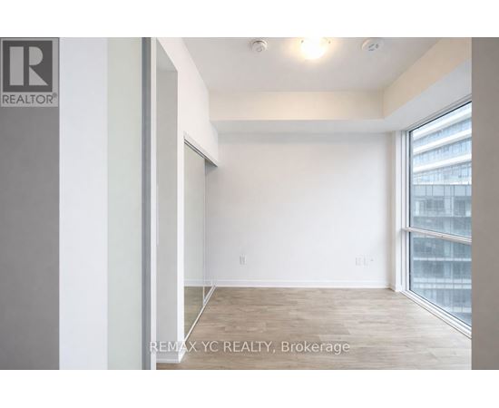 A room with a large window and a wooden floor.