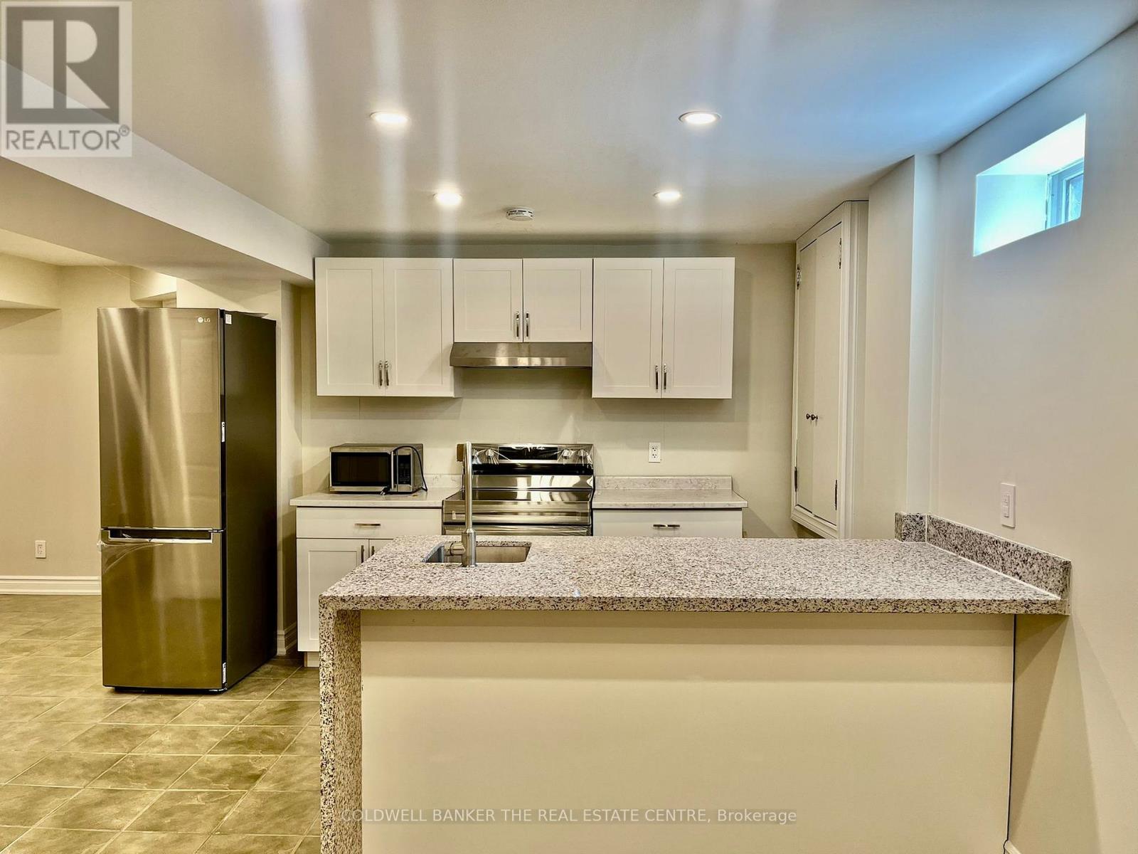 A kitchen with granite countertops and stainless steel appliances.