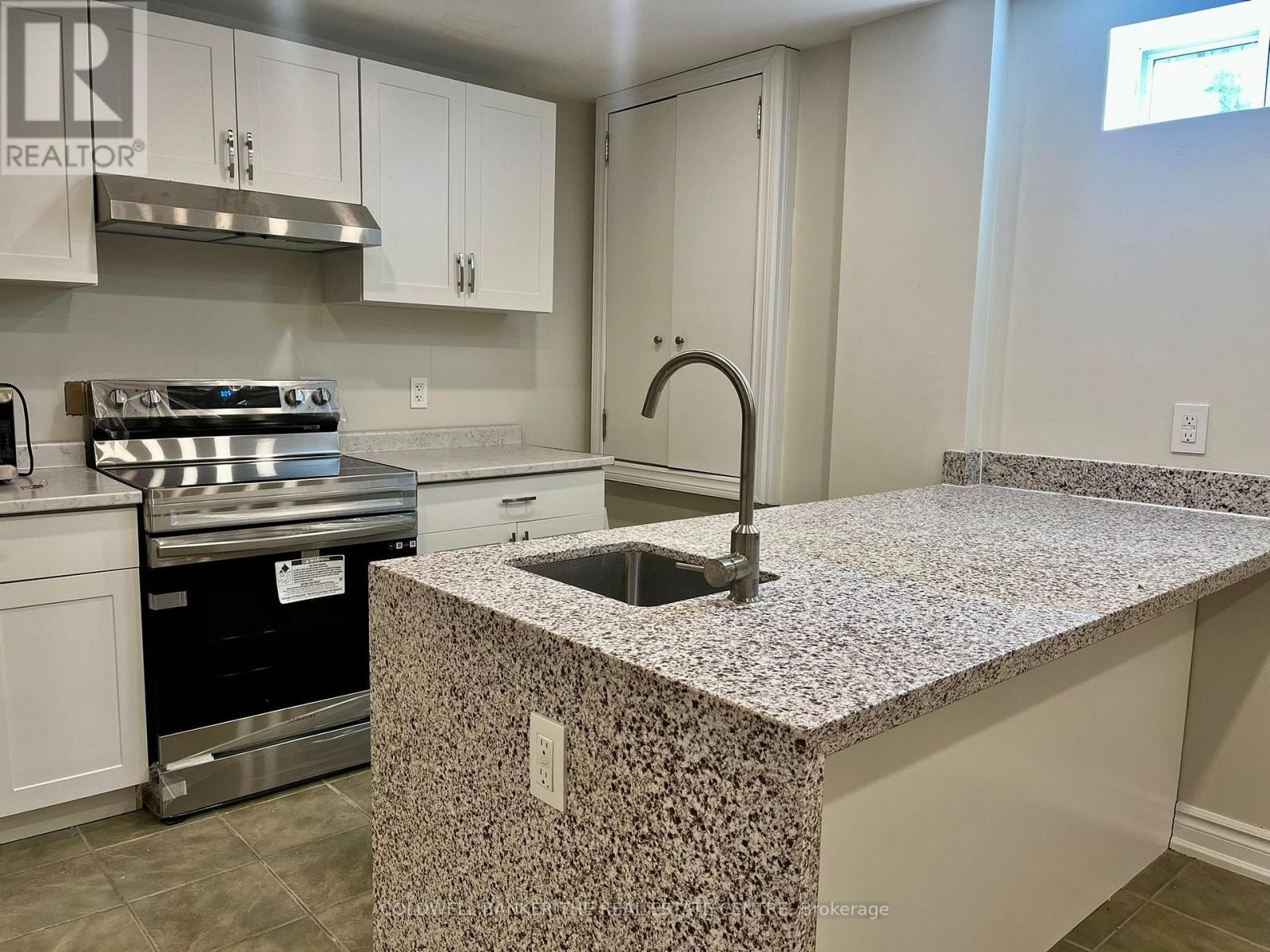 A kitchen with a granite countertop and stainless steel appliances.