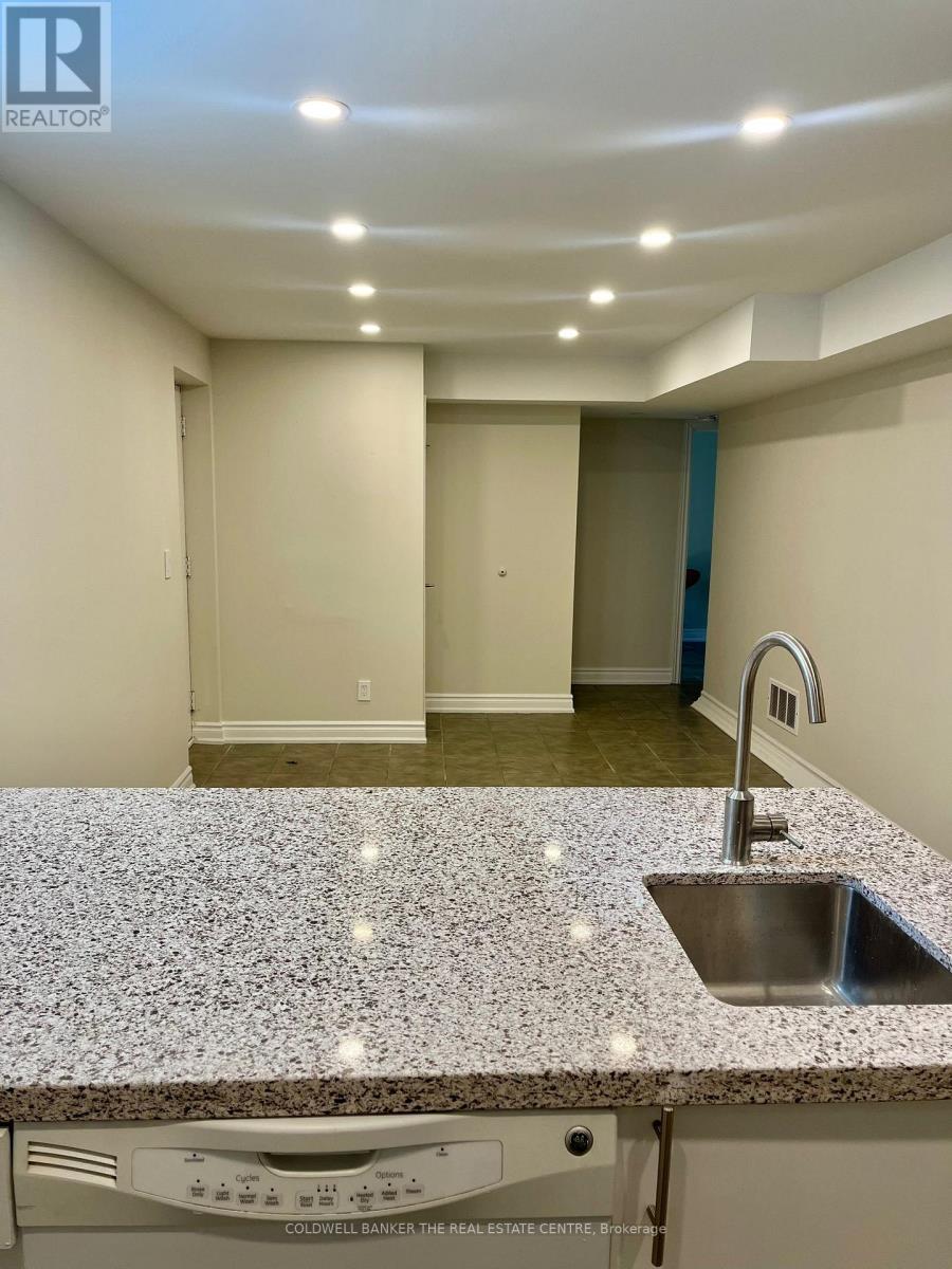 A kitchen with granite countertops and a stainless steel sink.