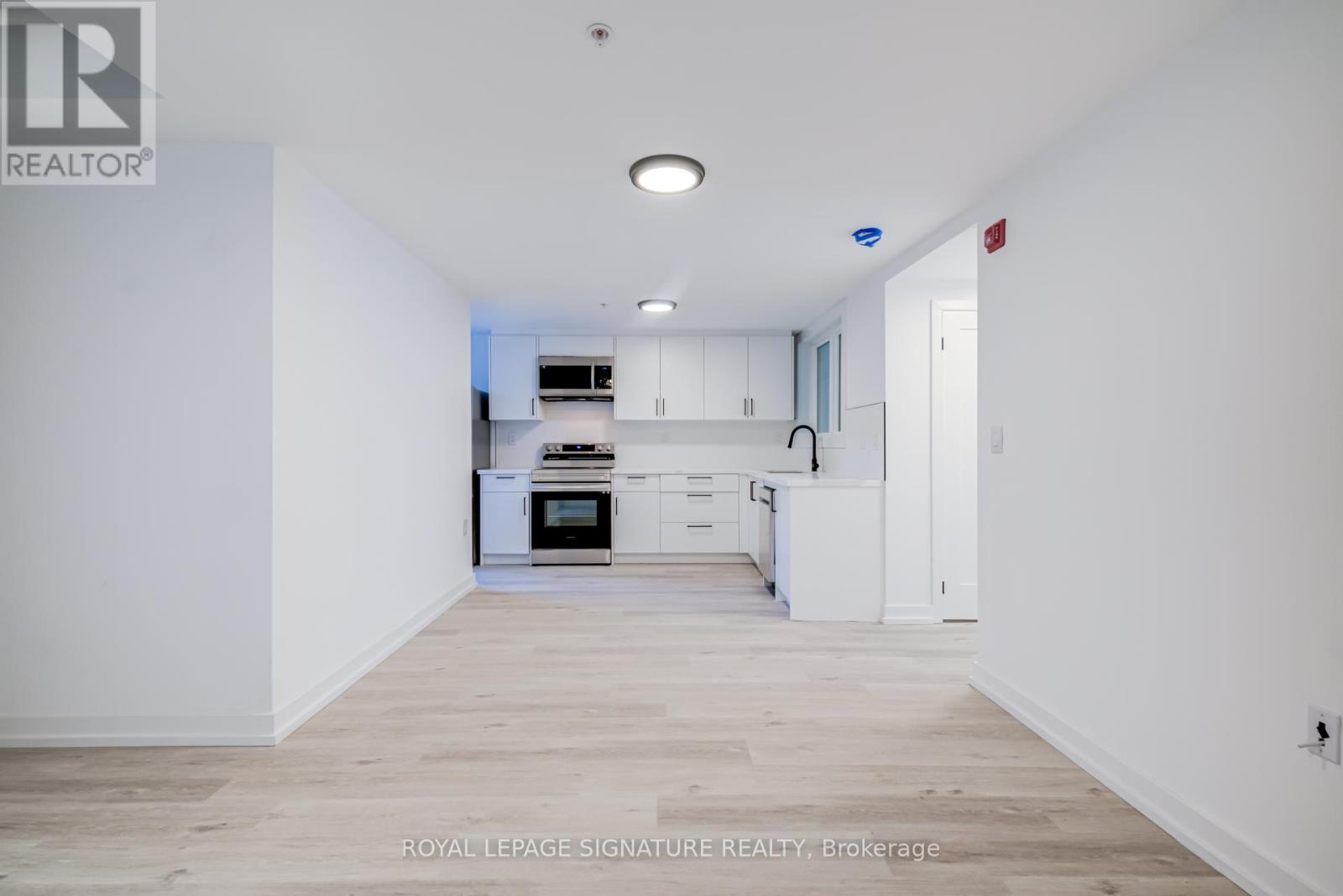 A white kitchen with wooden floors and white walls.