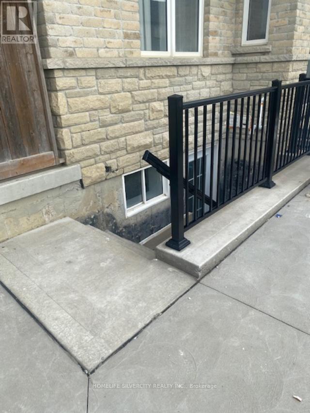 A black metal railing on a concrete step outside a building.