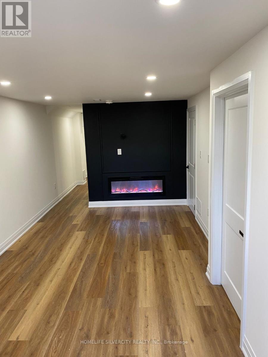 A room with wooden flooring and a fireplace.
