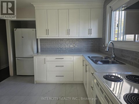 A kitchen with white cabinets and a black stove top.