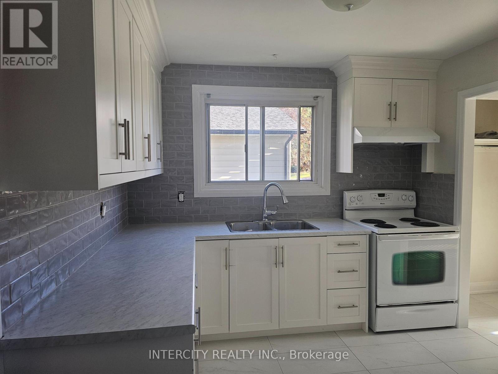 A kitchen with a white stove and cabinets.