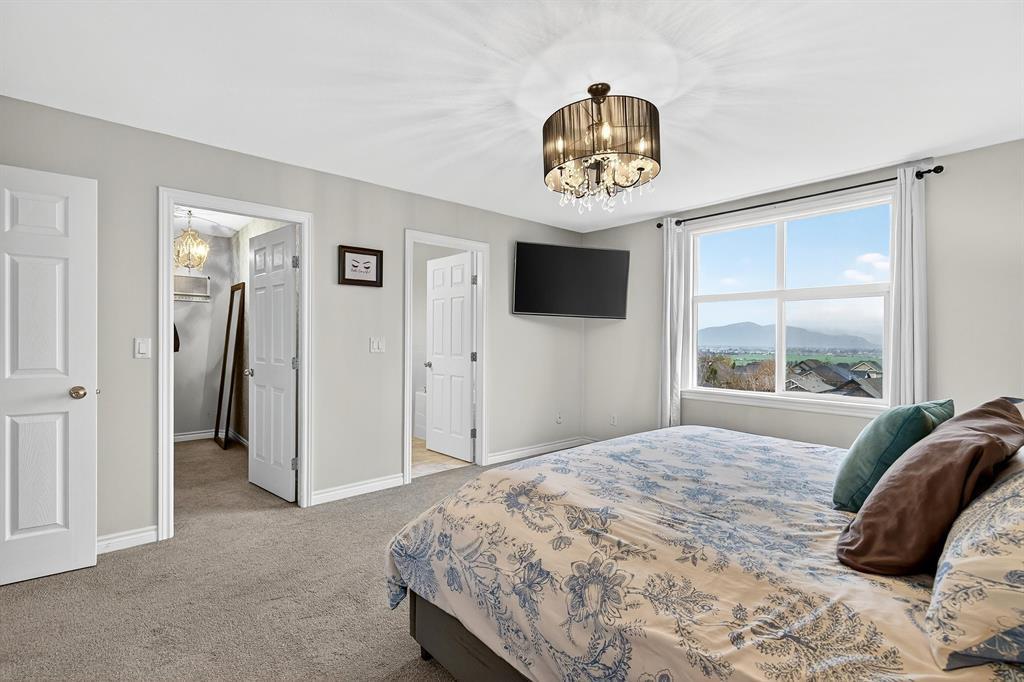 A bedroom with a large bed and a flat screen TV mounted on the wall.