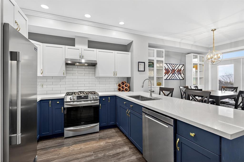 A modern kitchen with blue cabinets and stainless steel appliances.