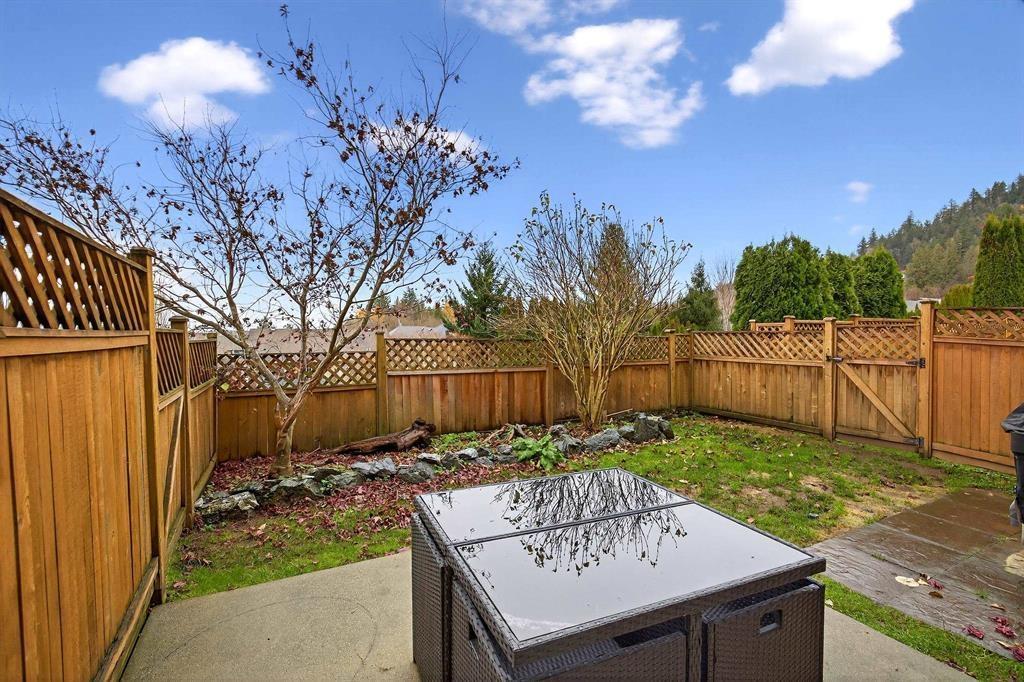 A backyard with a hot tub and a wooden fence.