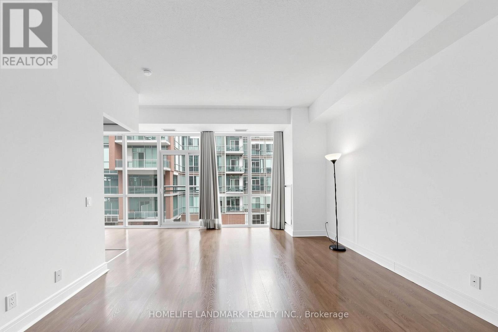 A spacious room with a view of a building outside the window.