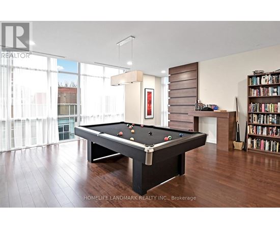 A pool table in a room with a bookshelf and a window.
