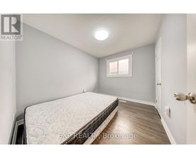 A bedroom with a bed, wooden floor, and a window.