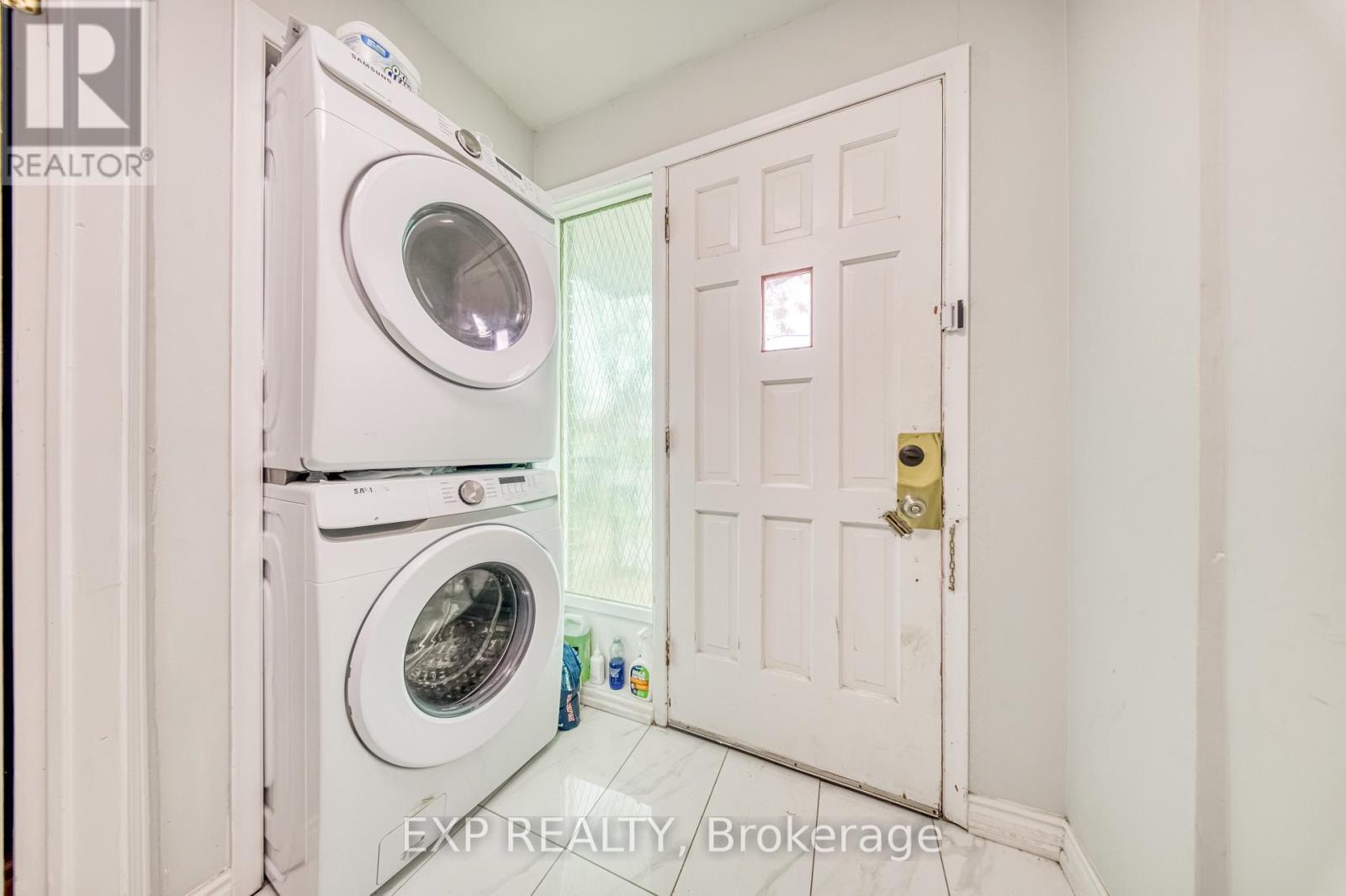 A white door is open to a laundry room with a washer and dryer.