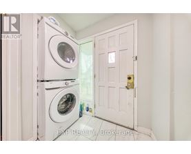A white door is open to a laundry room with a washer and dryer.