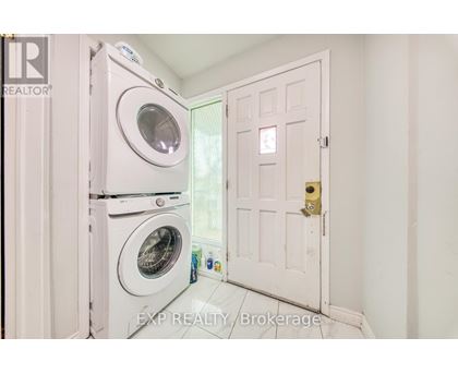 A white door is open to a laundry room with a washer and dryer.