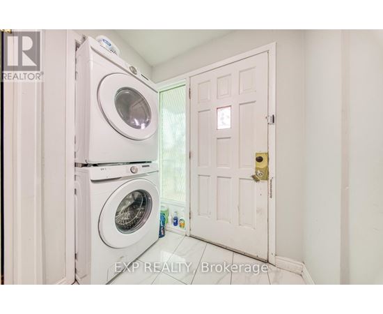 A white door is open to a laundry room with a washer and dryer.
