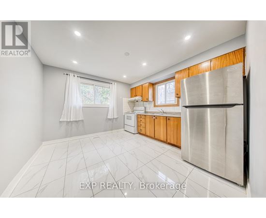 A kitchen with white tiled floors and wooden cabinets.