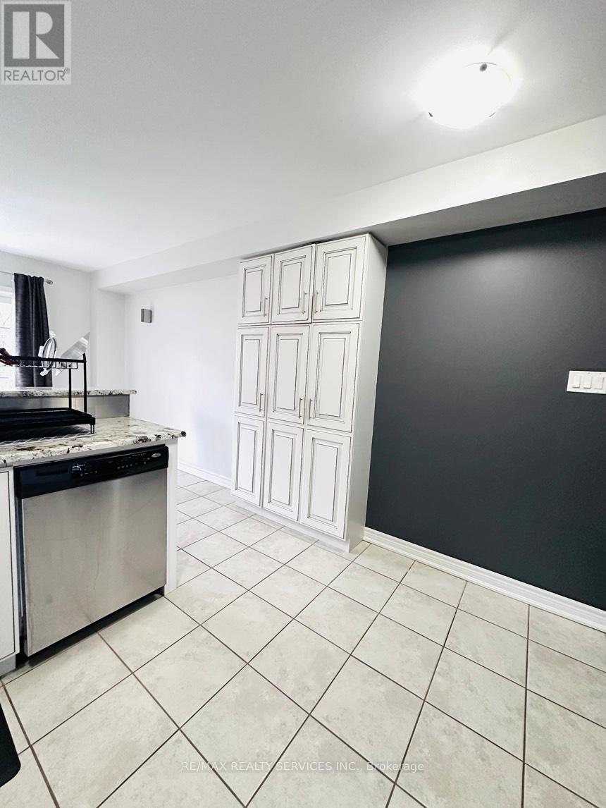 A kitchen with a stainless steel dishwasher and a white countertop.