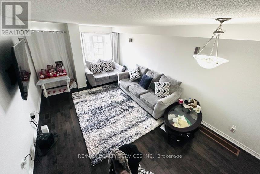 A living room with a grey couch and a rug.