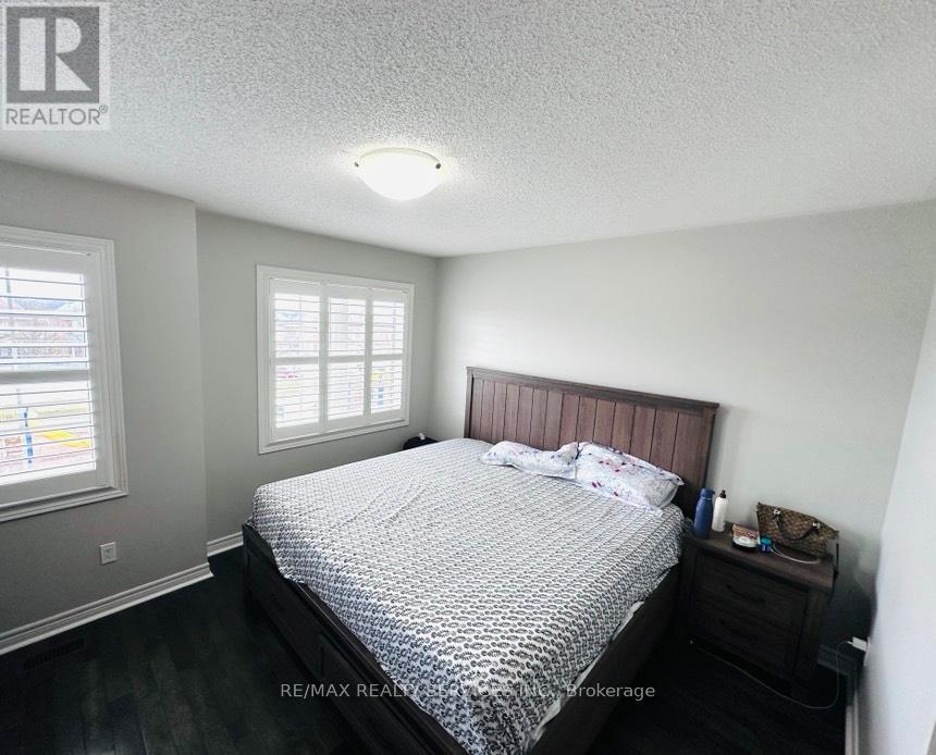 A bedroom with a bed, nightstand, and window.