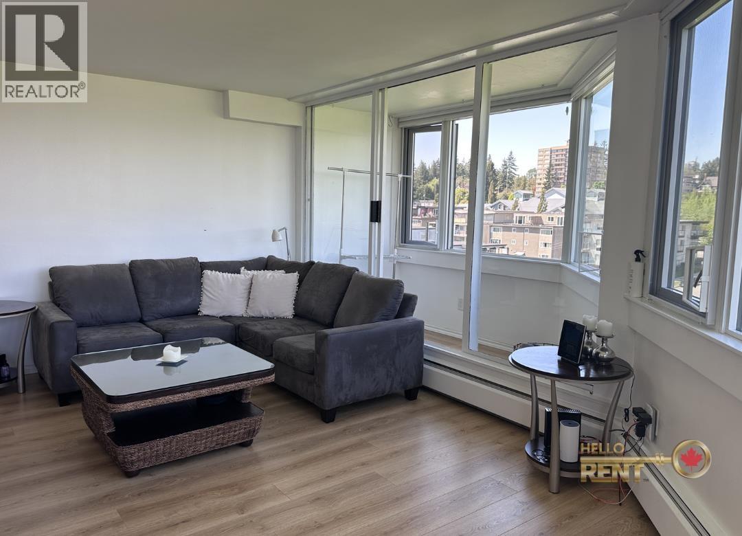 A living room with a grey couch and a glass table.