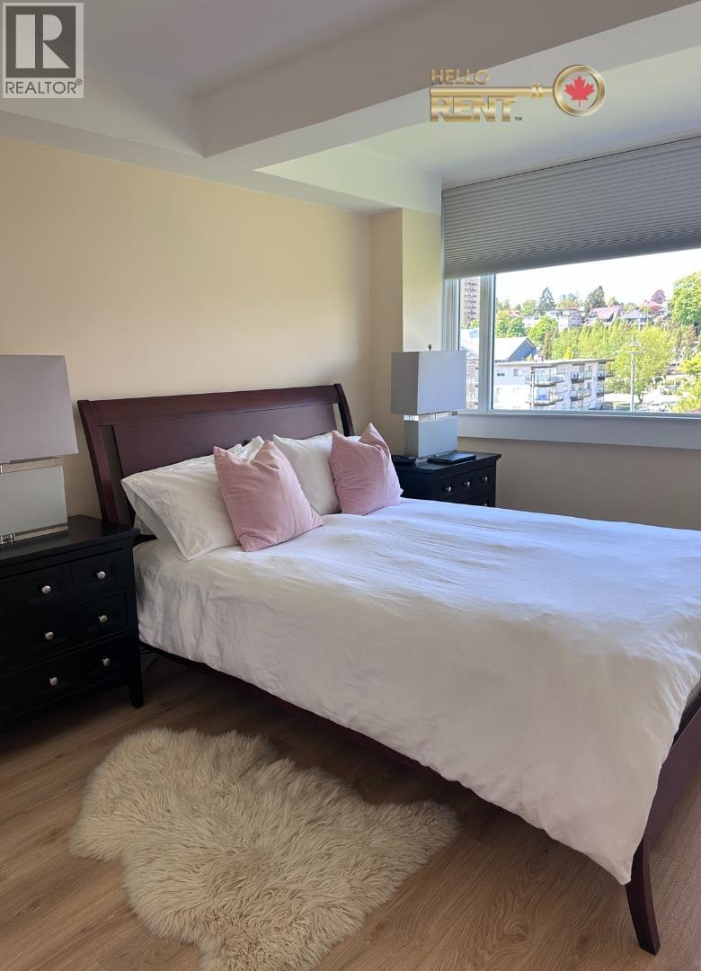 A bedroom with a bed, nightstand, and window.