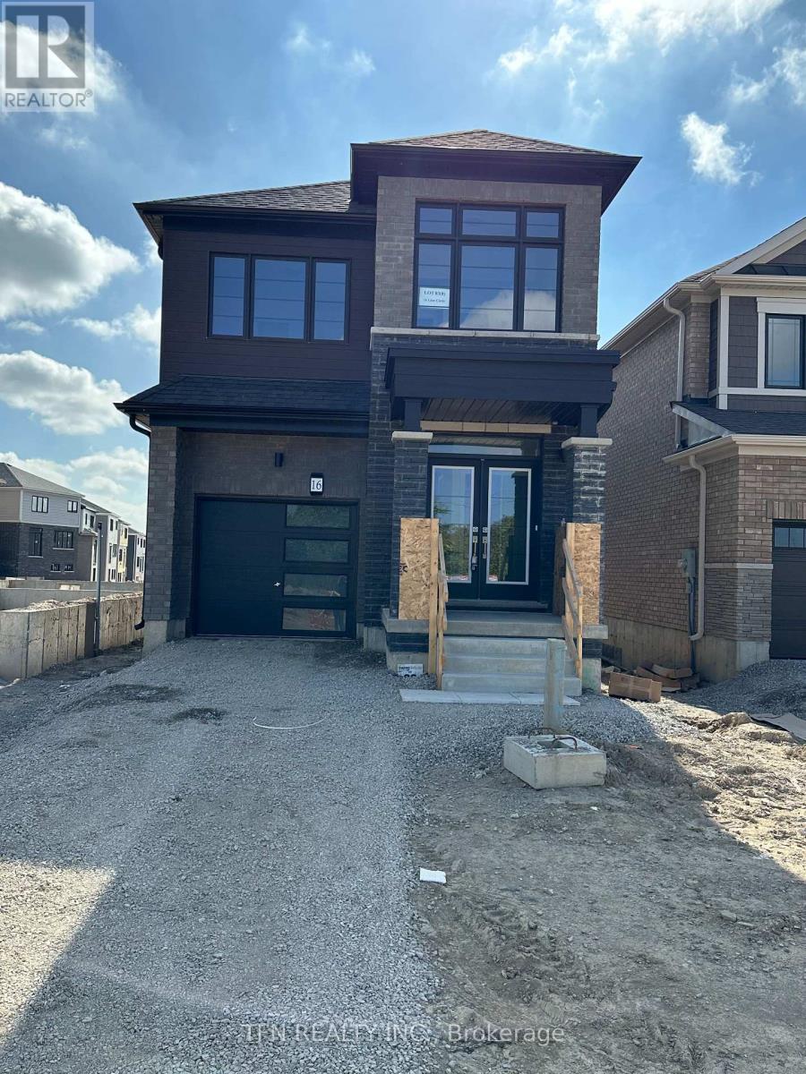 A house under construction with a gravel driveway in front.