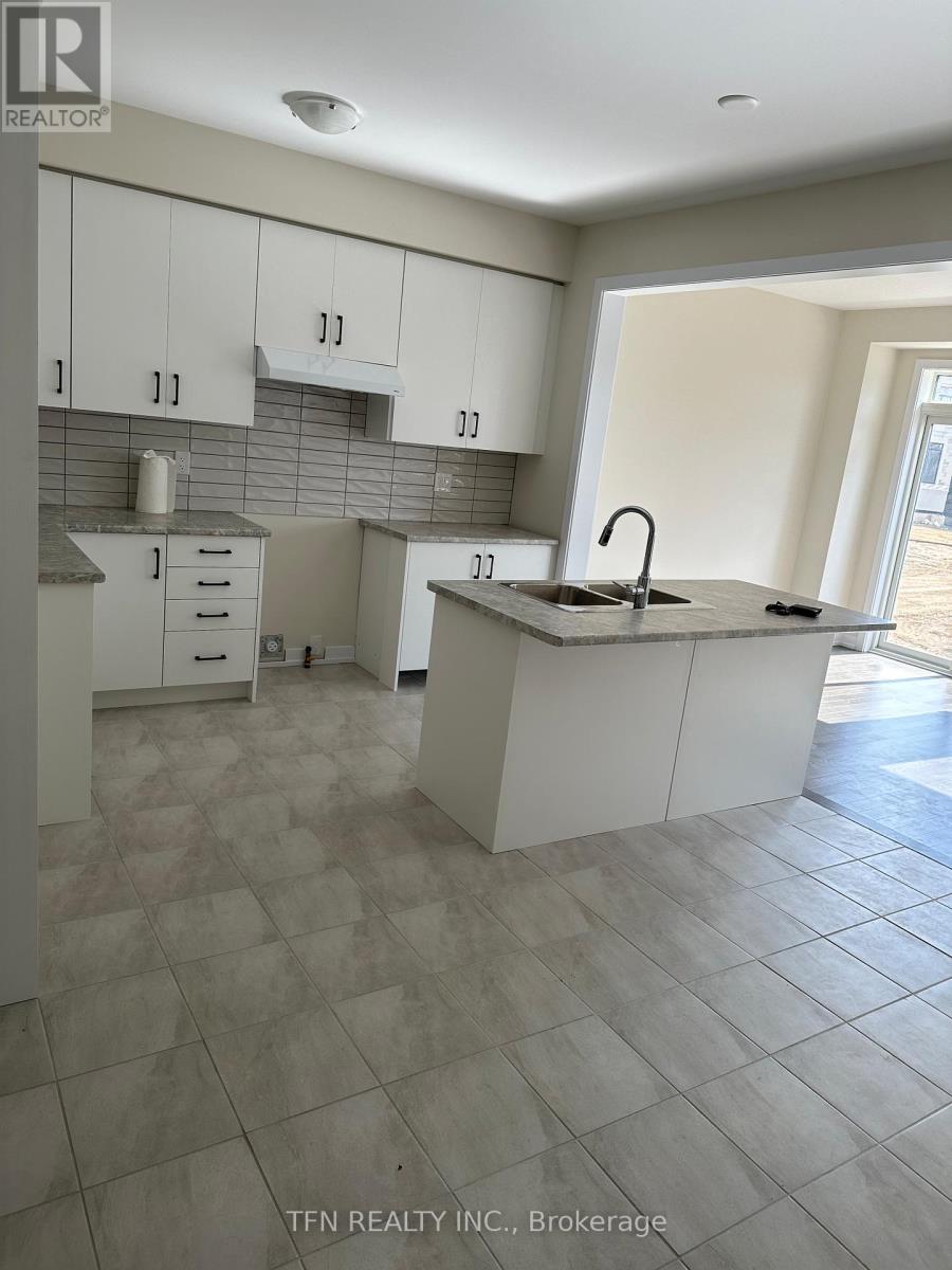 A kitchen with white cabinets and a tiled floor.