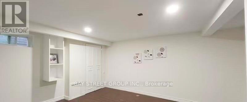 A realtor sign is on the wall in a white room.