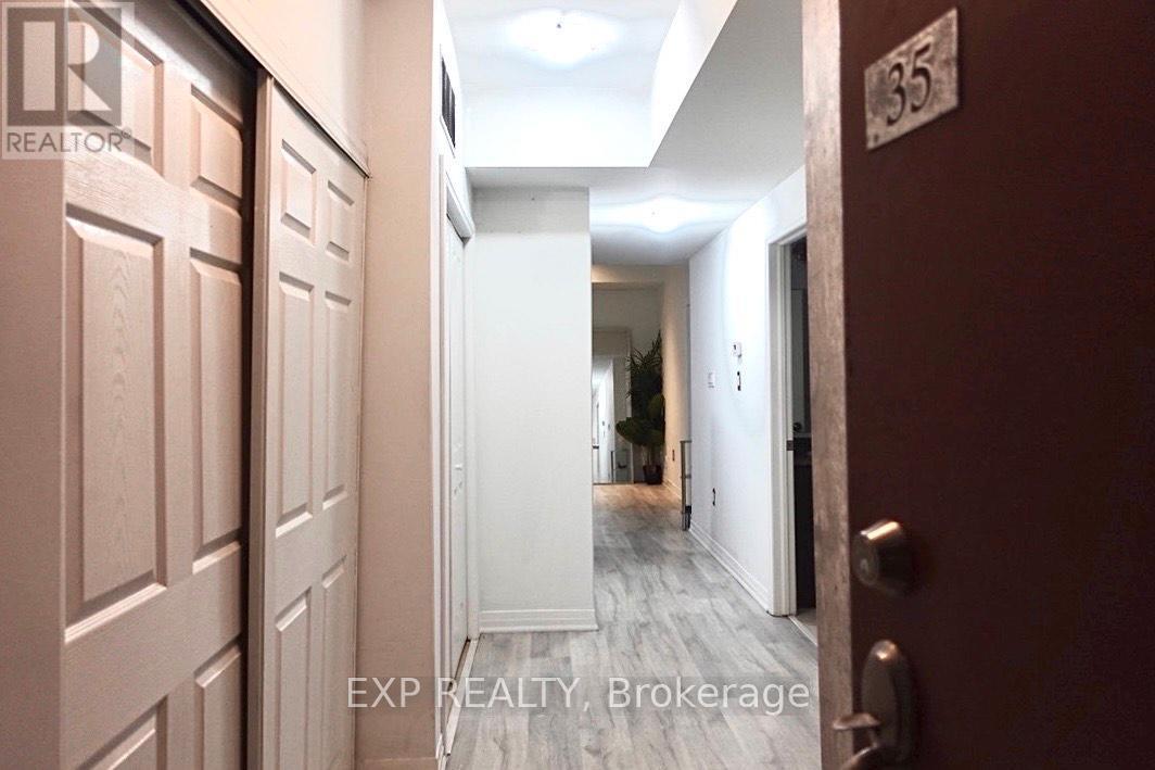 A hallway with a door on the left and a door on the right with a number 35 on the wall.