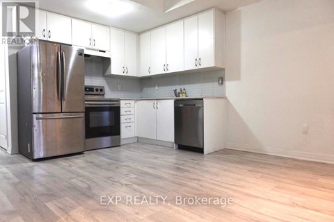 A kitchen with white cabinets and a stainless steel refrigerator.