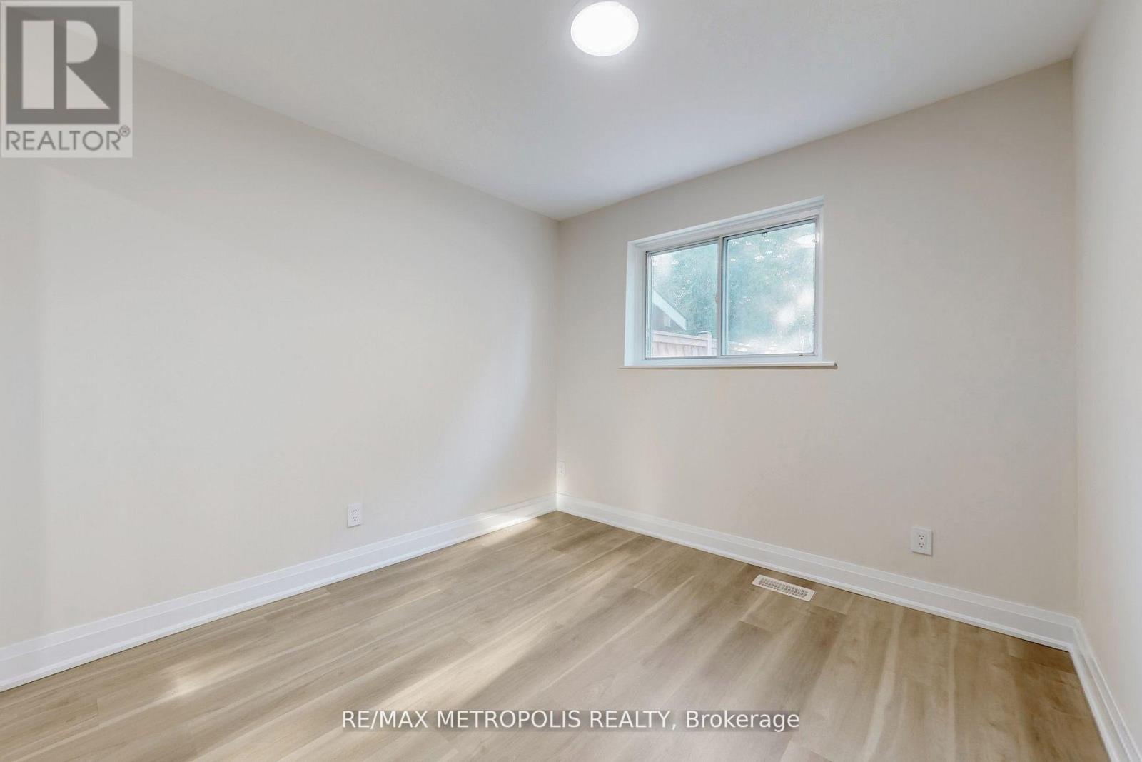 A room with a window and wooden flooring.