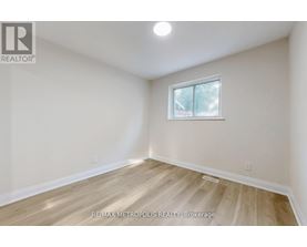 A room with a window and wooden flooring.