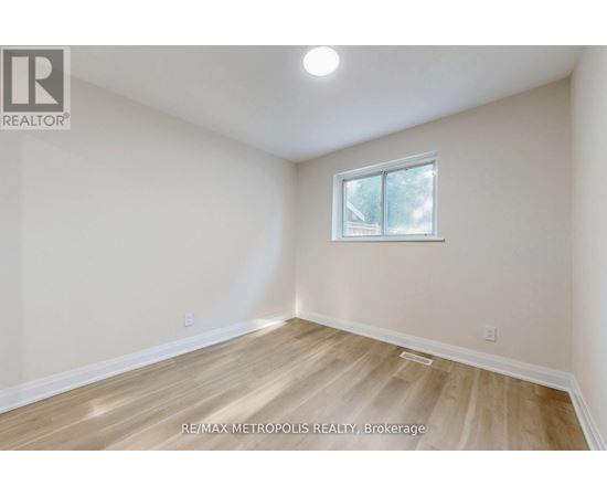 A room with a window and wooden flooring.