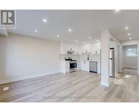 A spacious kitchen with white cabinets and a refrigerator.