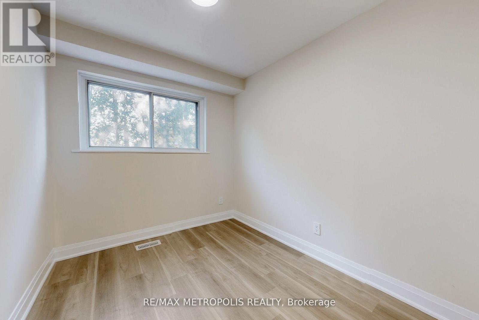 A room with a window and wooden flooring.