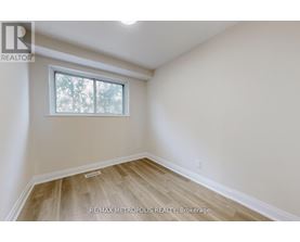 A room with a window and wooden flooring.