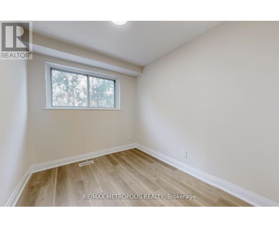 A room with a window and wooden flooring.