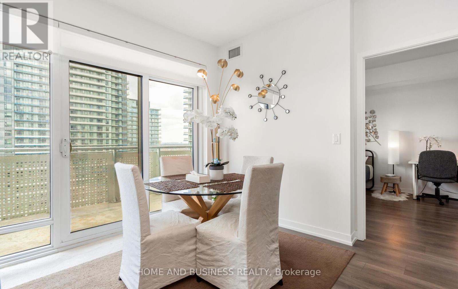 A dining room with a table set for two and a view of a balcony.