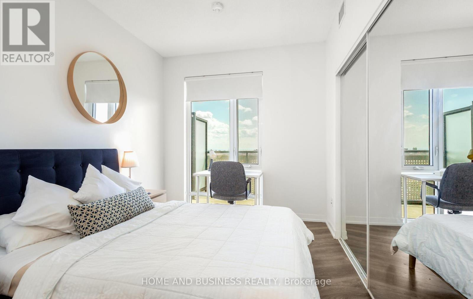 A bedroom with a large bed and a mirror on the wall.