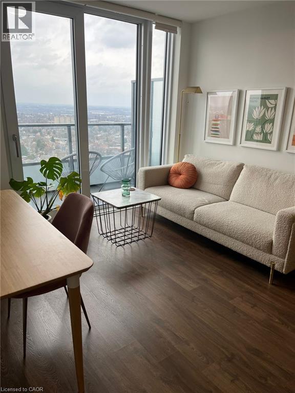 A living room with a couch, chair, and a table with a plant on it.