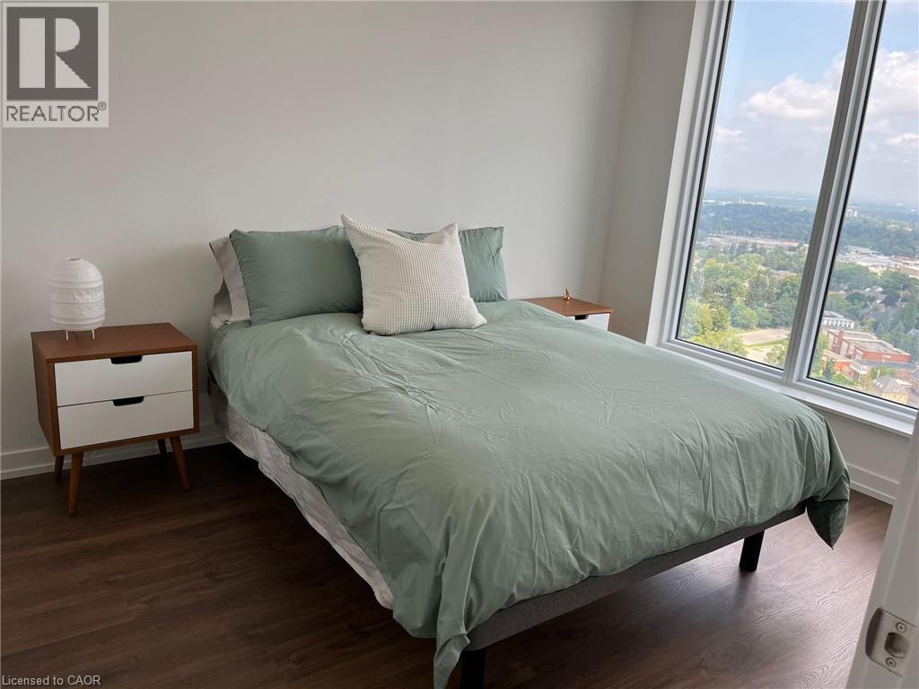 A bedroom with a bed, nightstand, and window.