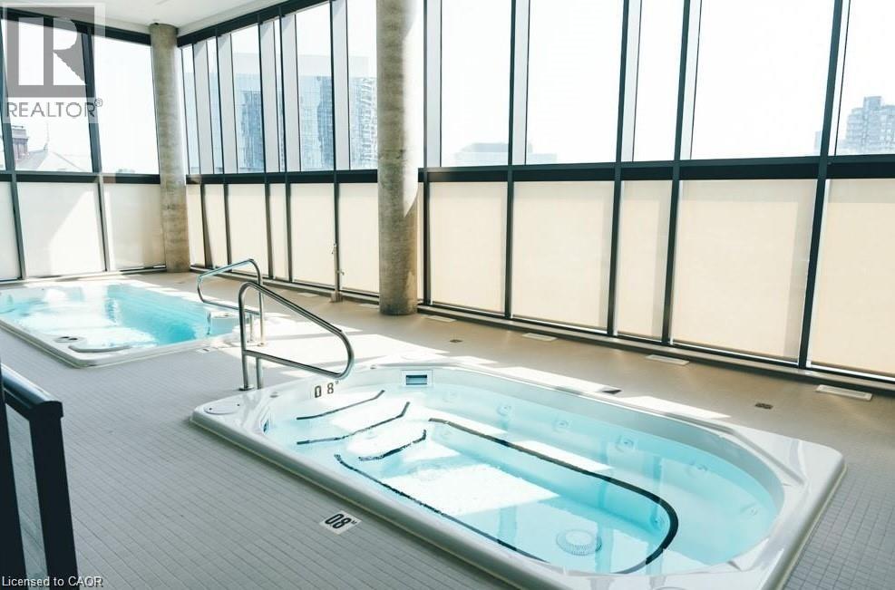 A large indoor swimming pool with a glass wall surrounding it.