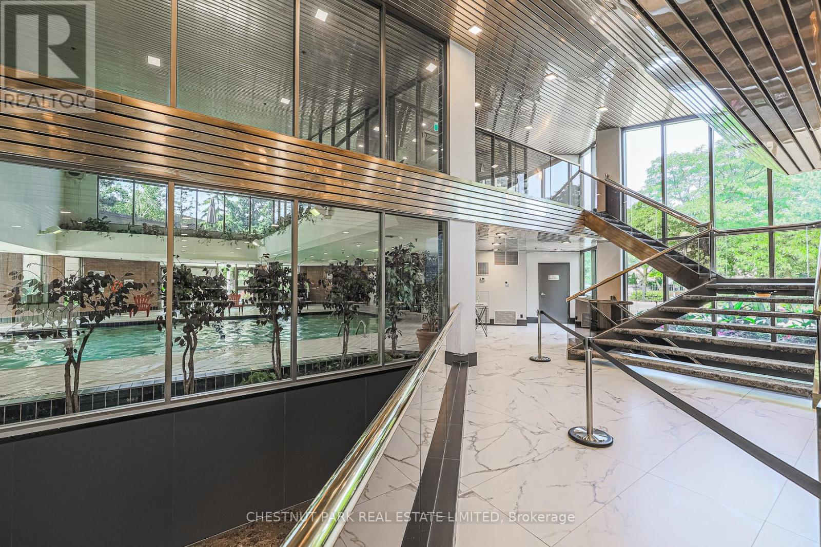A modern indoor space with a pool and a staircase.