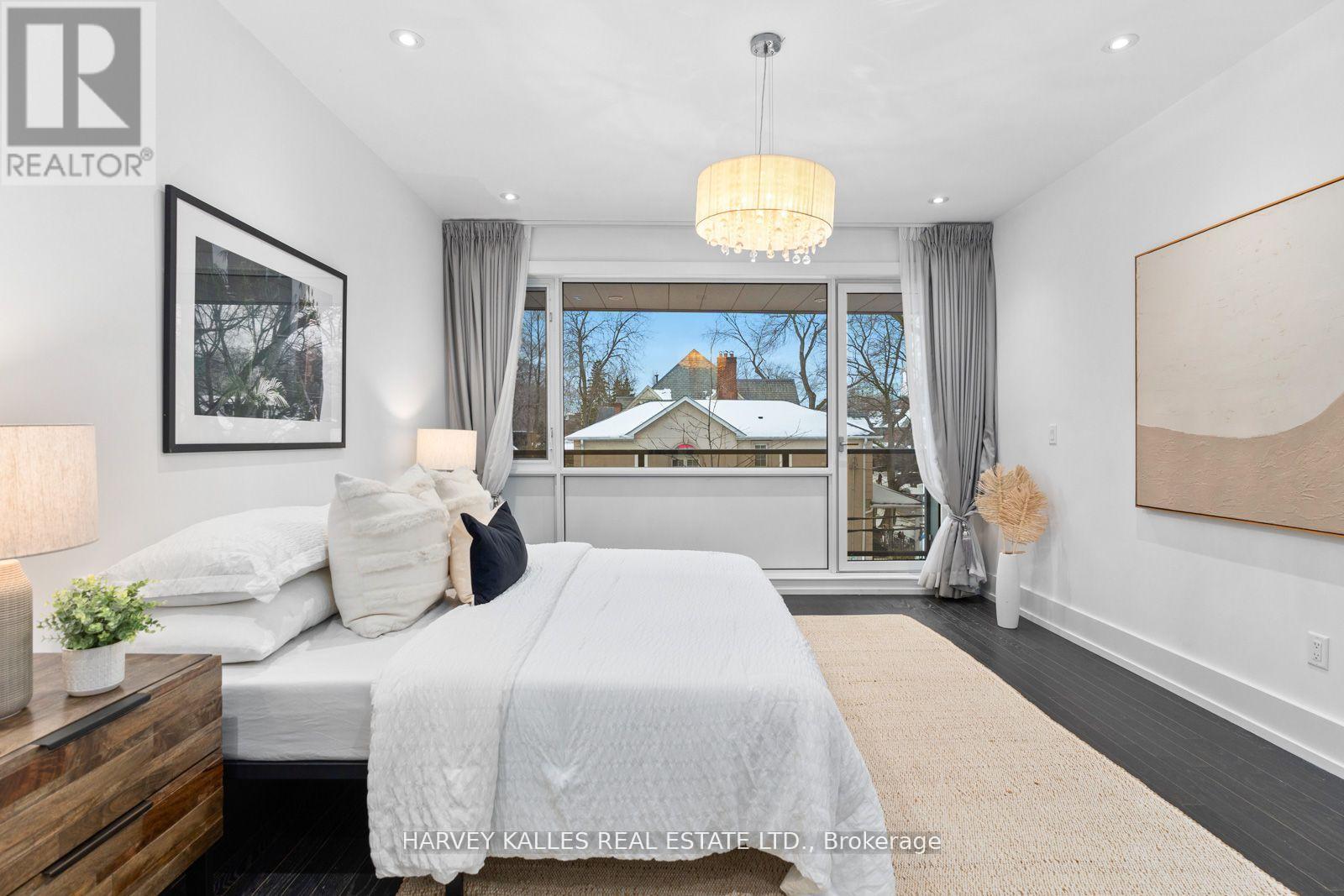 A bedroom with a large bed and a view of the outdoors through the window.