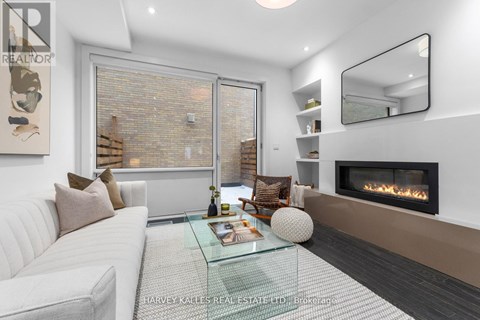 A modern living room with a glass coffee table and a fireplace.